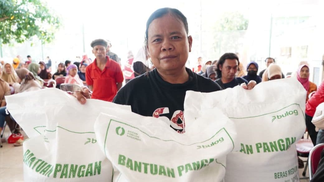 Seorang Ibu yang tengah menerima bantuan pangan Beras dari Badan Pangan Nasional (Bapanas) dan Perum Bulog. (Foto : Humas Bapanas)